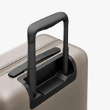 Monos Carry - On Pro Plus Luggage (23"), Hardside Spinner Suitcase with TSA Lock & Front Pocket, Airline Approved, Desert Taupe, Beige