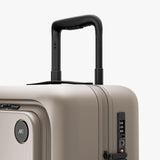 Monos Carry - On Pro Plus Luggage (23"), Hardside Spinner Suitcase with TSA Lock & Front Pocket, Airline Approved, Desert Taupe, Beige