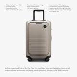 Monos Carry - On Pro Plus Luggage (23"), Hardside Spinner Suitcase with TSA Lock & Front Pocket, Airline Approved, Desert Taupe, Beige