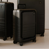 Monos Carry - On Pro Plus Luggage (23"), Hardside Spinner Suitcase with TSA Lock & Front Pocket, Airline Approved, Midnight Black