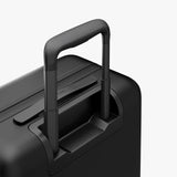 Monos Carry - On Pro Plus Luggage (23"), Hardside Spinner Suitcase with TSA Lock & Front Pocket, Airline Approved, Midnight Black