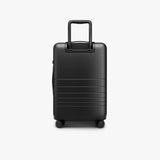 Monos Carry - On Pro Plus Luggage (23"), Hardside Spinner Suitcase with TSA Lock & Front Pocket, Airline Approved, Midnight Black