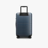 Monos Carry - On Pro Plus Luggage (23"), Hardside Spinner Suitcase with TSA Lock & Front Pocket, Airline Approved, Ocean Blue