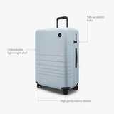 Monos Medium Checked Luggage (26.5"), Lightweight Hardside Spinner Suitcase with TSA Lock, Durable Travel Case, Blue Haze